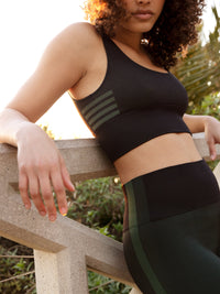 a person wearing black/green tank top and black/green shorts