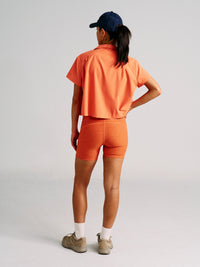 a person wearing an orange shirt with orange shorts