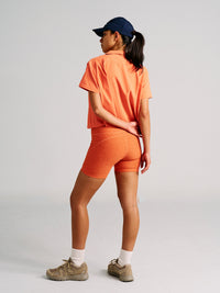 a person wearing an orange shirt with orange shorts