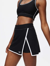 Model showcasing the Court Skort 2.5" in black with white trim and OV signature detail.