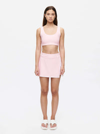 Fashion model wearing a pink outfit featuring the Court Skort 2.5" and coordinating crop top.
