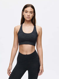 Model posing in Doing Things Bra in Black, featuring a mesh backing for breathability.