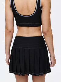 Back view of a model wearing the Doing Things 3" Skort with a pleated design and built-in shorts.