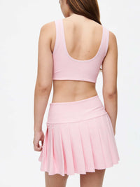 Wearing the Doing Things 3" Skort with built-in shorts and pleated design in pink.