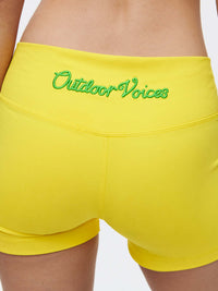 Back view of the Gemini 3" Short featuring Outdoor Voices logo on vibrant yellow fabric.