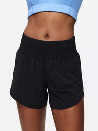 Close-up of model wearing LightSpeed 3" Short in Black, featuring a high-waisted stretchy band and pockets.