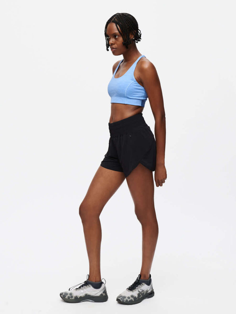 Model in a side view wearing LightSpeed 3" Short in Black with a budge-proof band and pockets, for running.