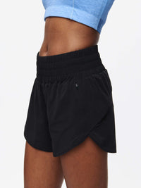 Side view of model wearing LightSpeed 3" Short in Black, featuring a budge-proof band and zip pocket.