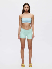 Model showcasing the Love Bra bandeau top in a soft blue color paired with mint green shorts.