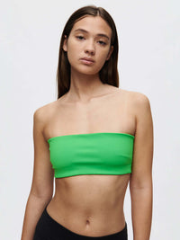 Model showcasing the Love Bra in vibrant green, featuring soft Bubble Wrap fabric and signature silicone gripper band.