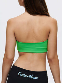 Back view of a model wearing the vibrant green Love Bra bandeau top from Outdoor Voices.
