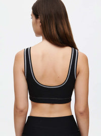 Back view of a woman wearing the Orbit Bra with contrast stitching in Textured Compression fabric.