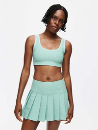 A model showcasing the Orbit Bra paired with a matching skirt, highlighting the soft-fit style and vibrant color.