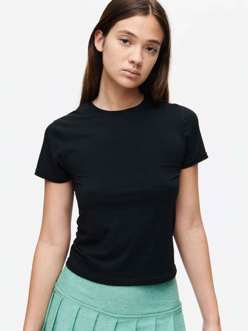 Model wearing ThinkFast Jersey Baby Tee in black, showcasing its soft and breathable fabric.