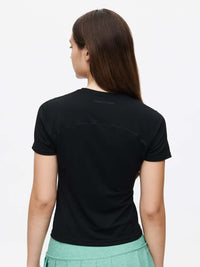 Back view of a model wearing the ThinkFast Jersey Baby Tee in black, showcasing its sleek design and soft fabric.