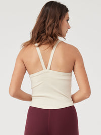 a person wearing a beige tank top