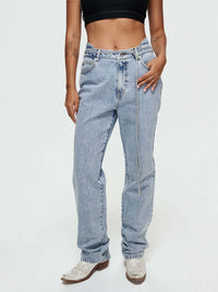 Cowgirl Jean featuring a mid-rise, straight silhouette, removable lasso-style belt, and durable denim for rugged wear.