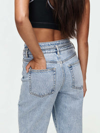 Back view of a model wearing Cowgirl Jean with mid-rise waist and straight silhouette, showing pockets.