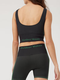 a person wearing black/green tank top and black/green shorts