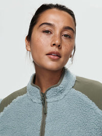 Close-up of model wearing Candy Fleece Jacket in light blue, featuring a soft fleece texture and mock neck.