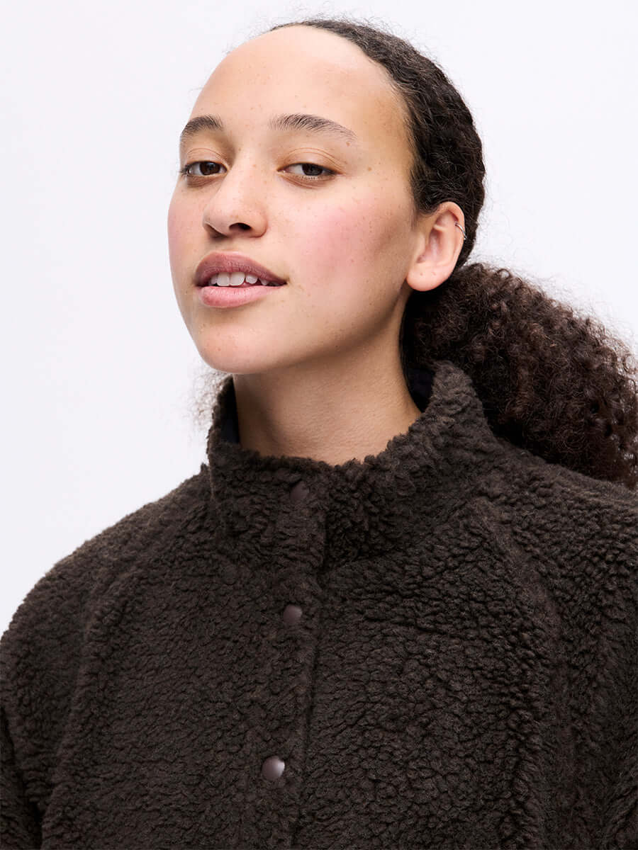 Model posing in Candy Fleece Snap Jacket in Chocolate Brown, featuring a soft fleece texture and snap front.