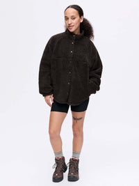 Model smiling in Candy Fleece Snap Jacket in Dark Brown, featuring an oversized fit and snap closure.