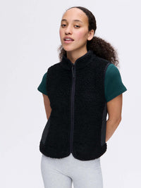 Model wearing Candy Fleece Vest in Black, featuring zippered front pockets and a cozy mock neck.