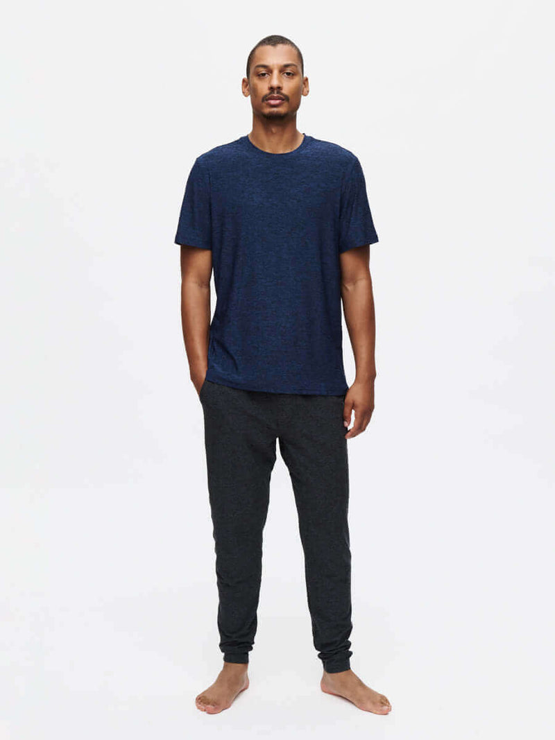 Model standing in relaxed pose wearing CloudKnit Slim Sweatpant in Dark Grey, with soft fabric and lightweight feel.