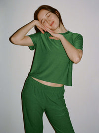 Model in a joyful pose wearing CloudKnit Wide Leg Pant in Green, with soft and breathable fabric.