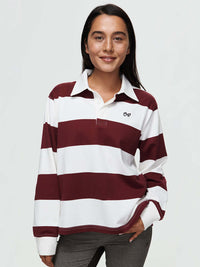 Model wearing Club Polo, a yarn-dyed rugby polo with striped design, ribbed cuffs, and hand-embroidered signature.