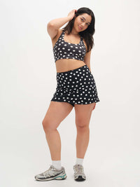 Model posing in Club Skort featuring playful polka dots, styled with matching crop top for activewear.