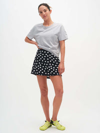 Model wearing Club Skort in Black with white polka dots, featuring a cute bow at the waist for added style.