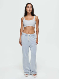 Model standing in Desert Pant in soft blue, wide-leg denim cotton terry with elastic waistband and drawcord.