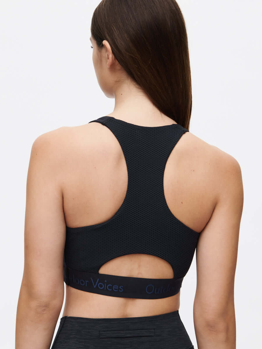 Back view of Doing Things Bra in Black, featuring a mesh backing and signature logo along the elastic band.