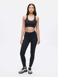 Model wearing Doing Things Bra in Black with comfortable fit and TechSweat fabric, paired with matching leggings.