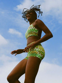 Doing Things Bra worn by an active woman, with vibrant green print against a sunny sky.