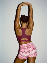 Back view of model wearing Doing Things Bra in Merlot with mesh backing and removable pads, ideal for active movement.