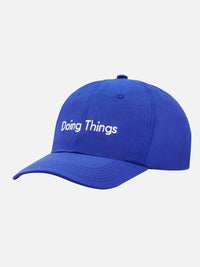 Side view of Doing Things Hat in blue, made of 100% recycled nylon Taslon with a curved brim.