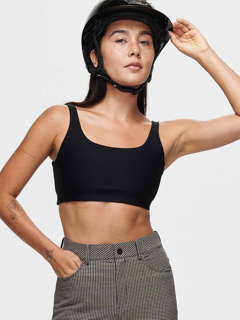 Model wearing Double Time Bra in Black, featuring a double scoop design and medium support for activewear.