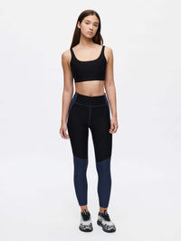 Model wearing Double Time Bra in Black with medium support and paired with high-waisted leggings for activewear.