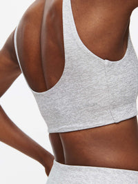 Back view of Double Time Bra in Light Grey with wide armholes and medium support design, for workouts.