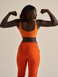 Back view of Double Time Bra in Orange, showing detailed scoop design and snug fit for activewear.