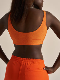 Back view of Double Time Bra in vibrant orange, featuring a snug fit and low support design.