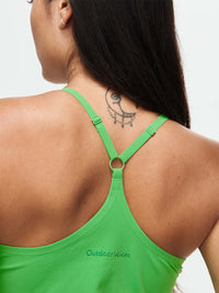 Back view of a woman wearing The Exercise Dress in vibrant green, with adjustable straps and Outdoor Voices branding.