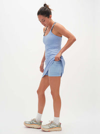 Model wearing The Exercise Dress in Light Blue with adjustable straps and built-in shorts liner, ready for activity.