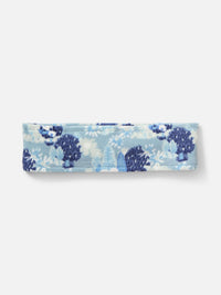 Flat lay of Frosted Headband in Blue, featuring Elf Garden print with pine trees and daisies.