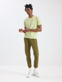 Model posing in GridTek Breezy Shortsleeve in Light Green, ultra-breathable performance apparel for activewear.