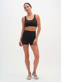 Model posing in Echo 3.5" Short in Black, featuring a tall waistband and supportive stretch.