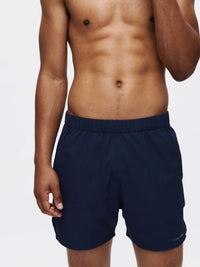 Model wearing High Stride 5" Short with Pockets in Navy, featuring elastic waistband and front pockets.