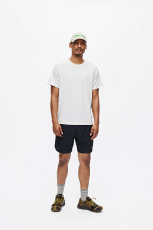 Man standing in High Stride 7" Short with Pockets in Black, showing built-in shorts liner and pockets.